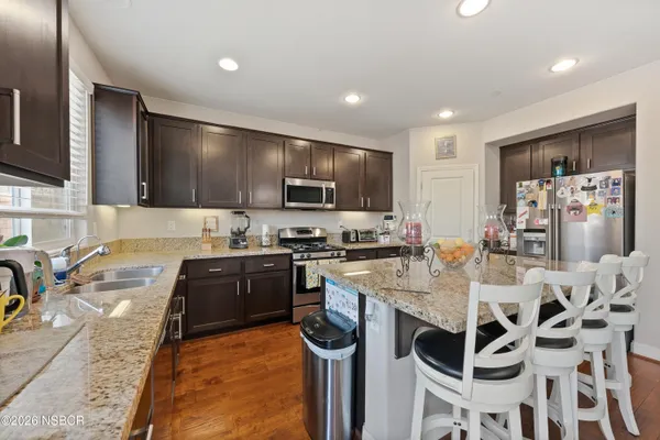 a kitchen with stainless steel appliances granite countertop a sink stove and refrigerator