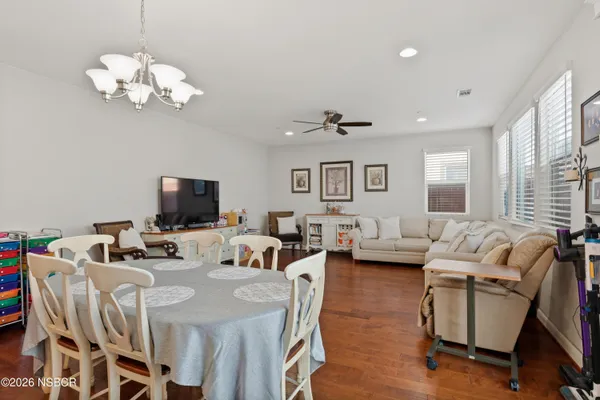 a view of a dining room with furniture a chandelier and wooden floor