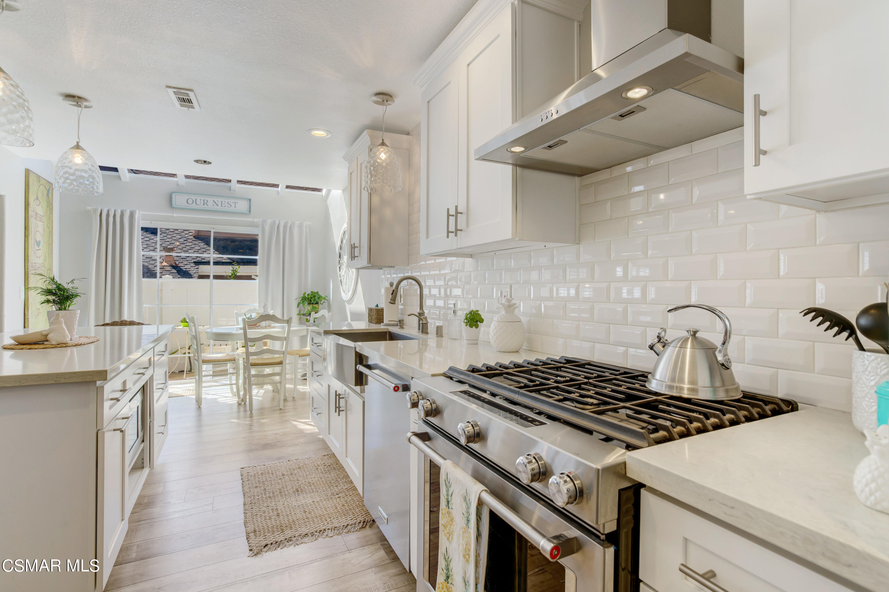 1948 Rory Lane, Unit 4 Simi Valley, CA 93063 - Photo 12 of 23 a kitchen with a stove a sink dishwasher and white cabinets with wooden floor