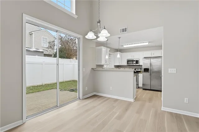 a view of a kitchen with refrigerator and wooden floor