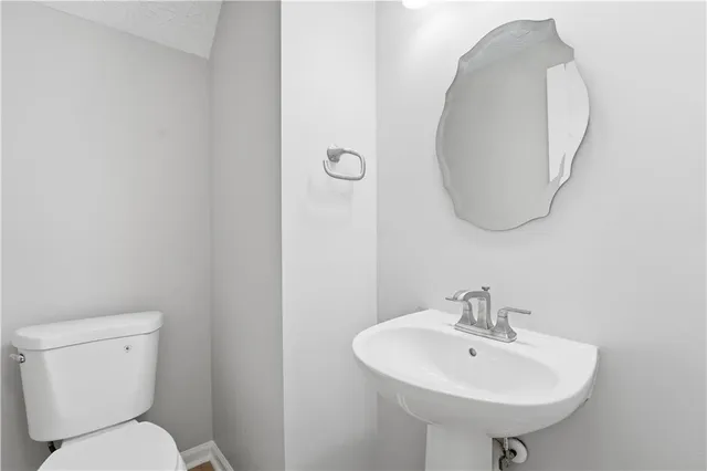 a bathroom with a toilet a sink and a mirror