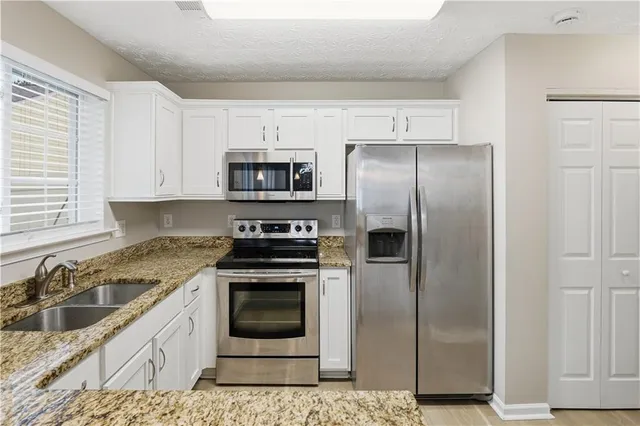 a kitchen with a refrigerator sink and stove