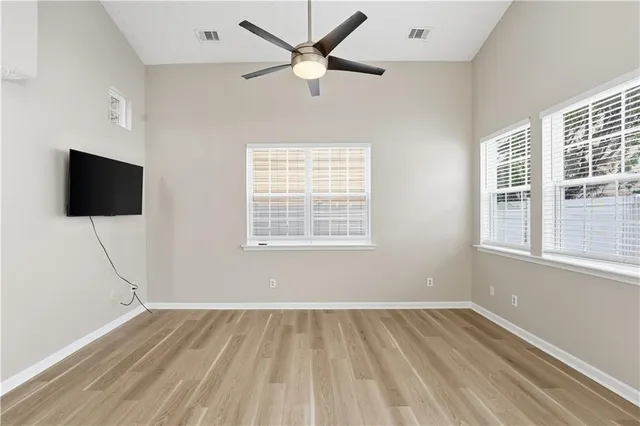a view of an empty room with a window and a flat screen tv