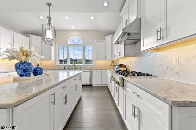a kitchen with stainless steel appliances granite countertop a sink stove and cabinets