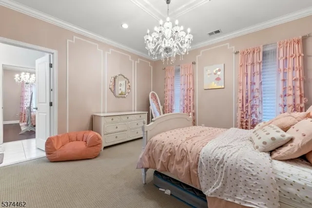 a spacious bedroom with a bed and a chandelier