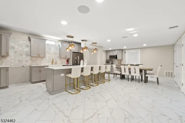 a large white kitchen with lots of counter space and dining table