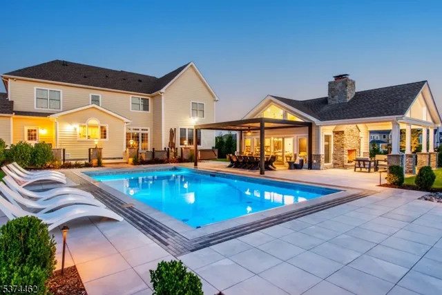 a view of a house with swimming pool and sitting area