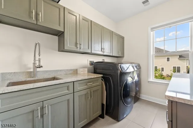 a utility room with cabinets washer and dryer
