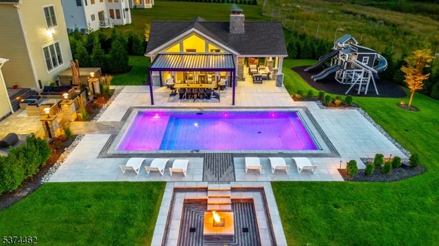 a view of swimming pool with lawn chairs and a yard