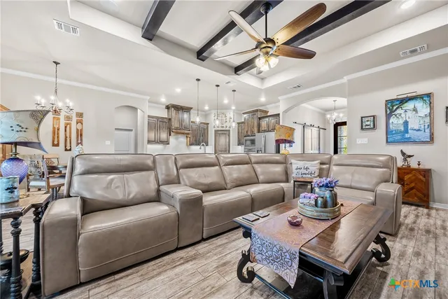 a living room with furniture a ceiling fan and a rug