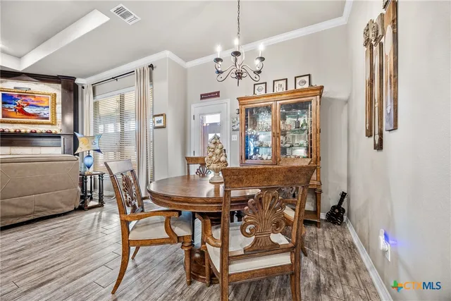 a view of a dining room with furniture wooden floor and a chandelier