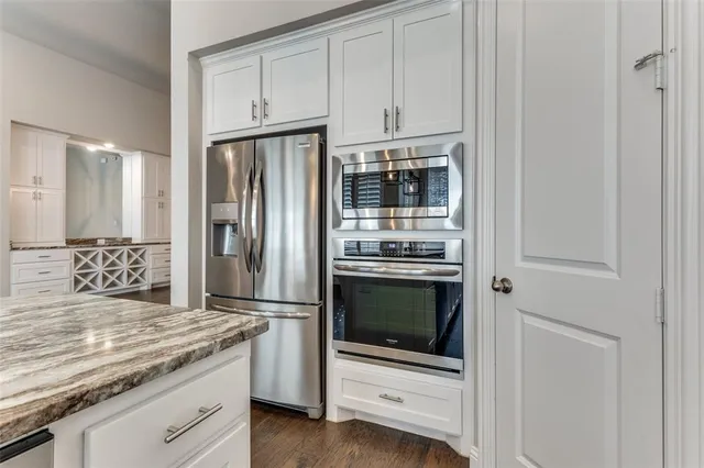 a kitchen with stainless steel appliances granite countertop a refrigerator stove and sink