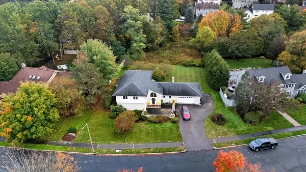 an aerial view of a house with garden space and street view