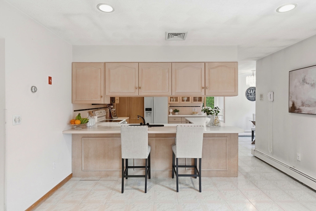 98 Lilah Lane Reading, MA 01867 - Photo 12 of 37 a kitchen with stainless steel appliances a stove a table and chairs