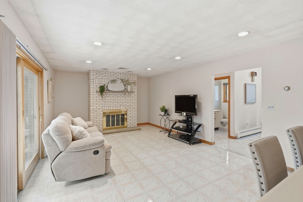 98 Lilah Lane Reading, MA 01867 - Photo 13 of 37 a living room with furniture flat screen tv and a fireplace