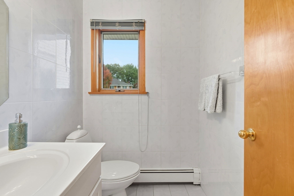 98 Lilah Lane Reading, MA 01867 - Photo 14 of 37 a bathroom with a granite countertop toilet a sink a mirror and shower