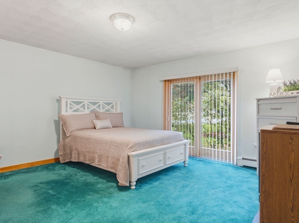 98 Lilah Lane Reading, MA 01867 - Photo 15 of 37 a bed sitting in a spacious bedroom next to a window