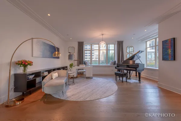 a living room with furniture a piano and a dining table