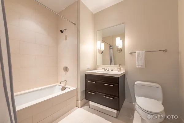 a bathroom with a sink toilet mirror and bathtub