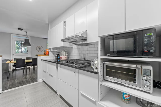 a kitchen with stainless steel appliances a stove a microwave and sink