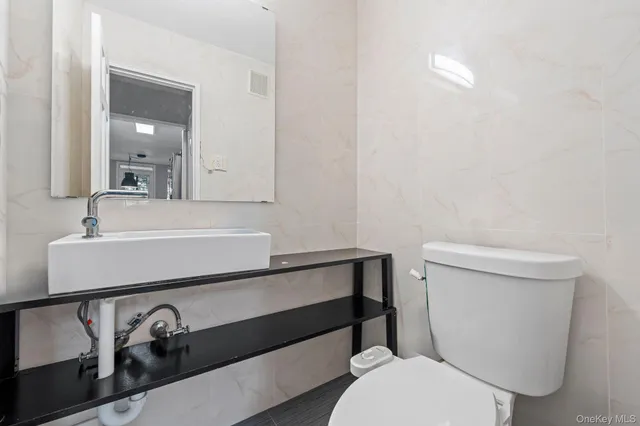 a bathroom with a sink a toilet and mirror