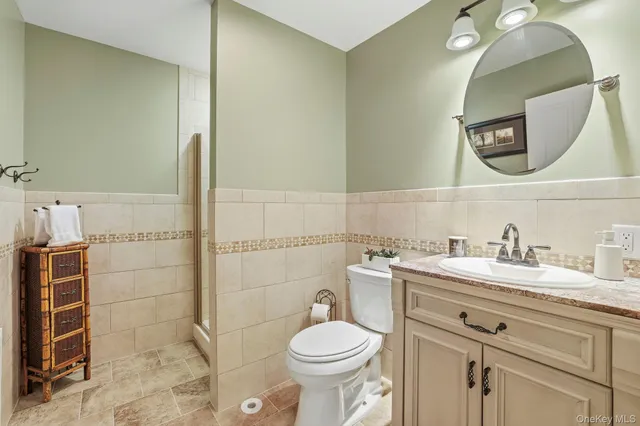 a bathroom with a granite countertop toilet sink and mirror