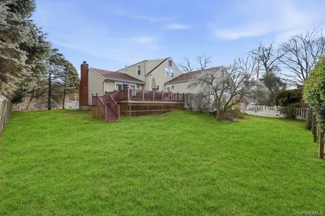 a view of a house with a big yard and large trees