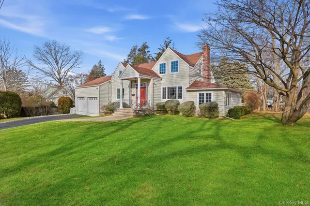 a front view of a house with a garden and trees