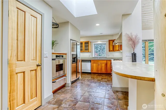 a kitchen with stainless steel appliances a stove a sink and a refrigerator
