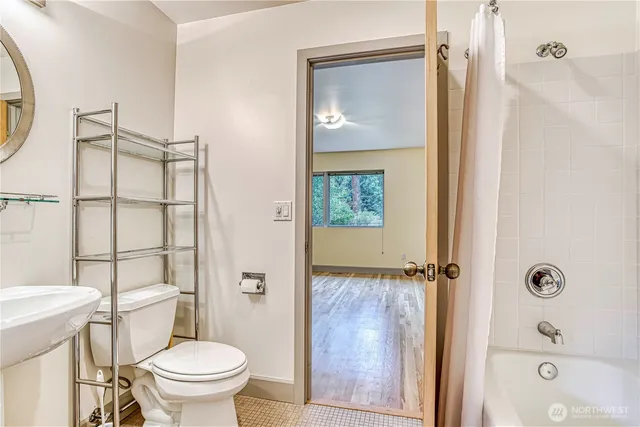 a view of an empty room with wooden floor and stairs
