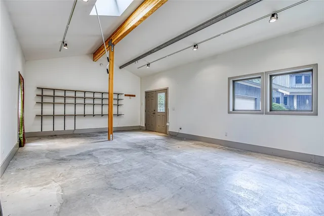 a view of an empty room with window and bathroom
