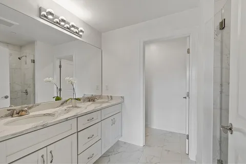 a bathroom with double sink and a mirror