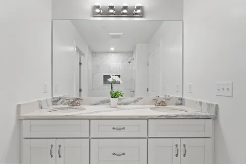 a bathroom with a sink double vanity and a mirror