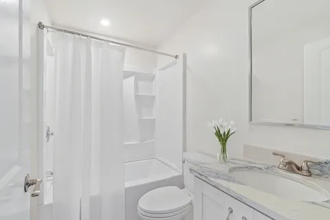 a bathroom with a granite countertop sink toilet and shower