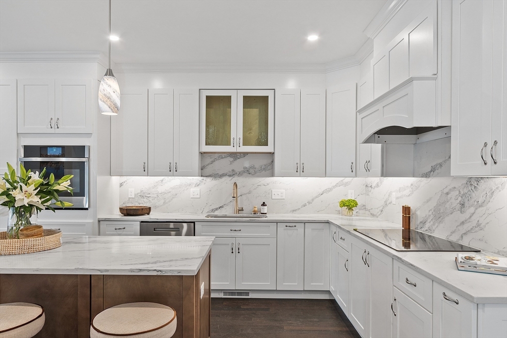 206 West Main Street, Unit 8 Georgetown, MA 01833 - Photo 6 of 38 a kitchen with sink stove and white cabinets with wooden floor
