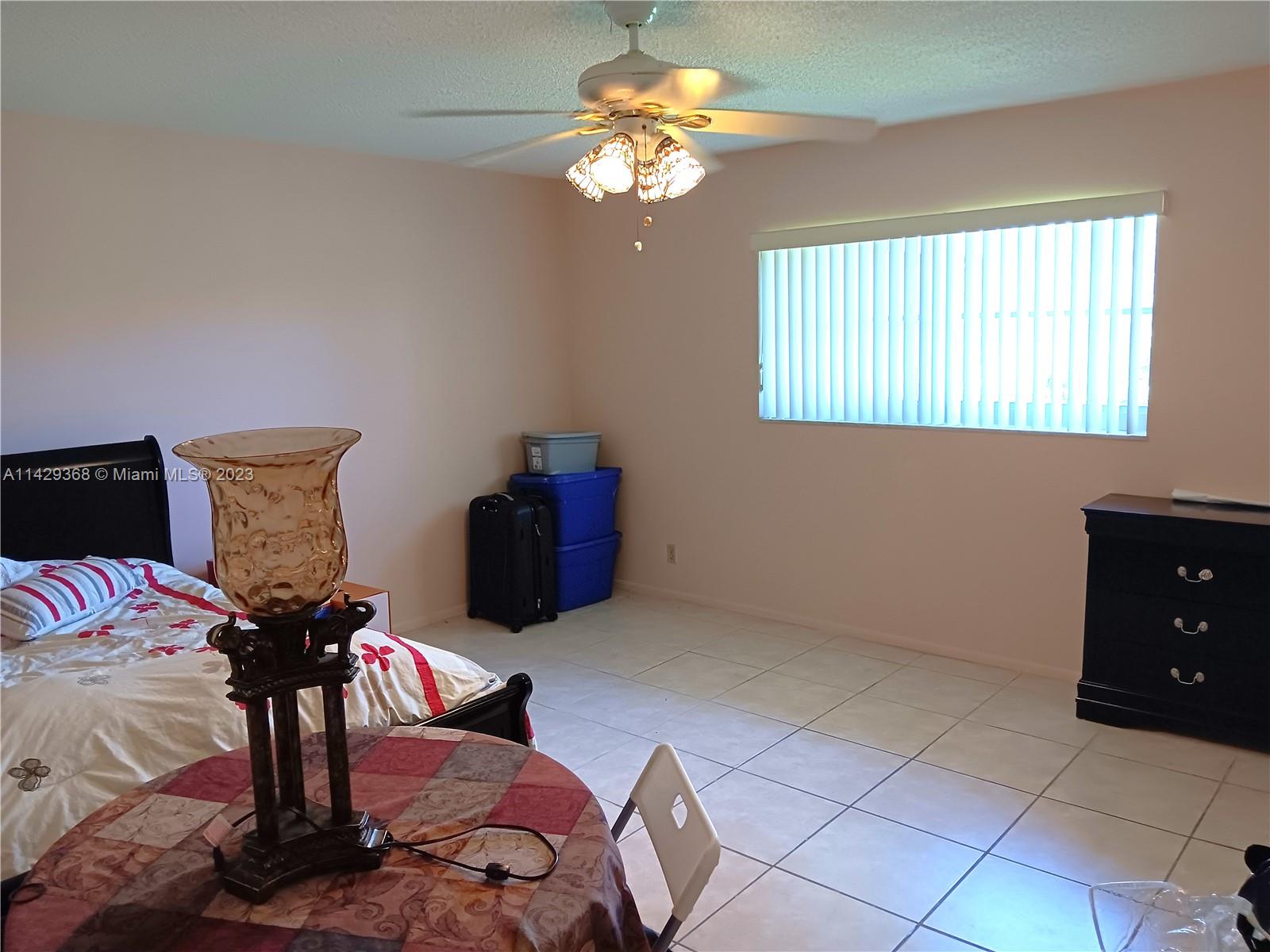 5790 Stirling Road, Unit 311 Hollywood, FL 33021 - Photo 11 of 36 a bedroom with a bed and a chandelier