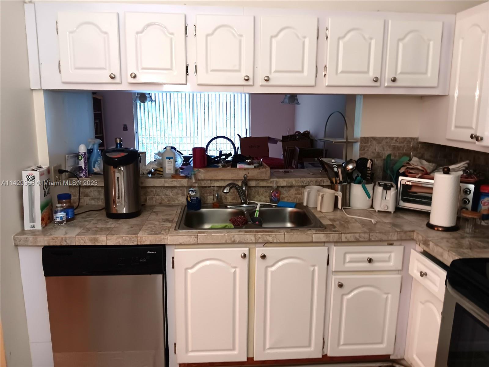 5790 Stirling Road, Unit 311 Hollywood, FL 33021 - Photo 21 of 36 a kitchen with granite countertop white cabinets and white appliances