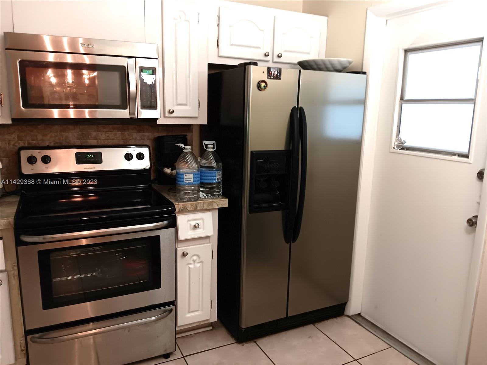 5790 Stirling Road, Unit 311 Hollywood, FL 33021 - Photo 22 of 36 a kitchen with stainless steel appliances a refrigerator stove and microwave