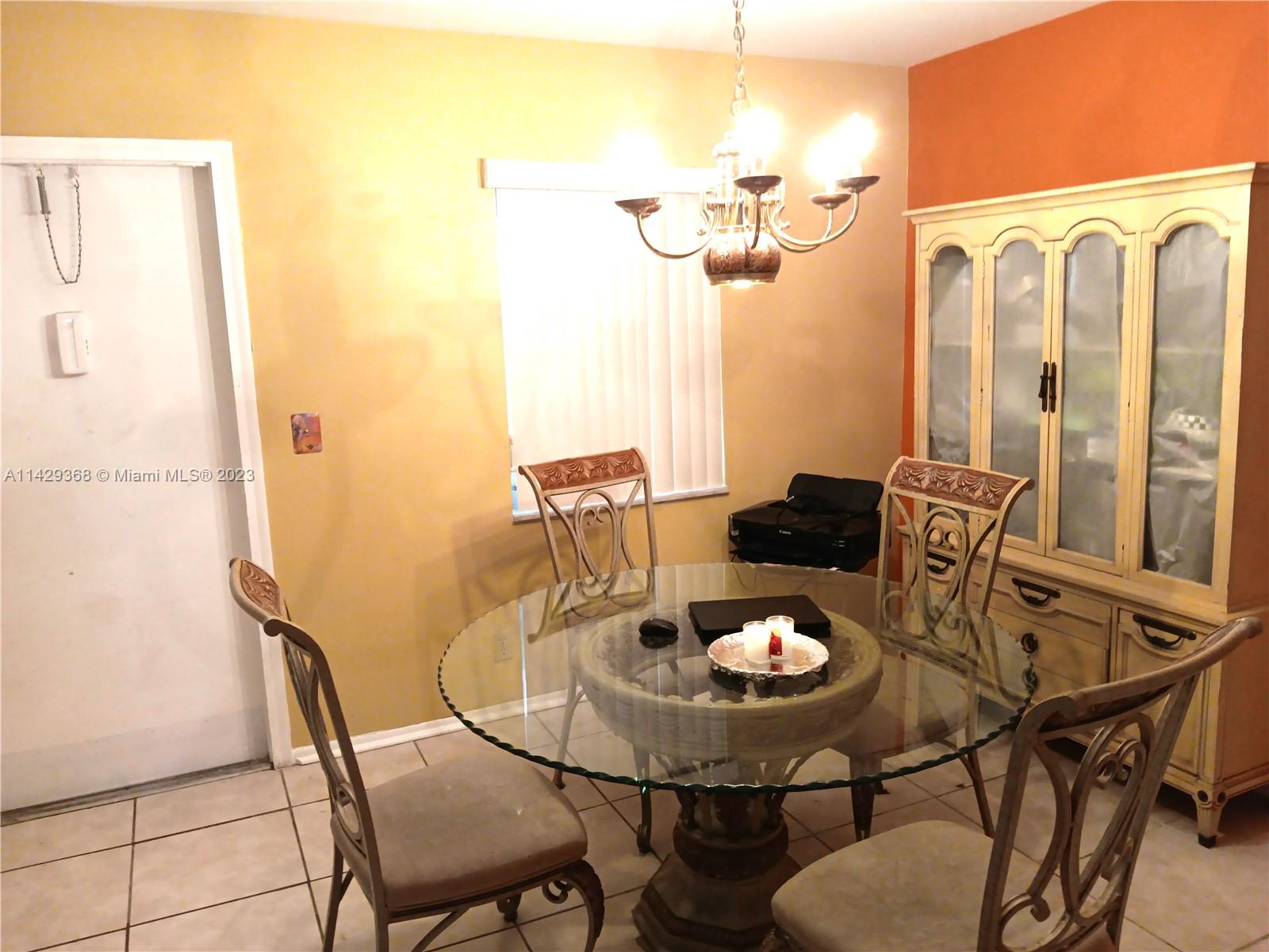 5790 Stirling Road, Unit 311 Hollywood, FL 33021 - Photo 23 of 36 a view of a dining room with furniture and chandelier