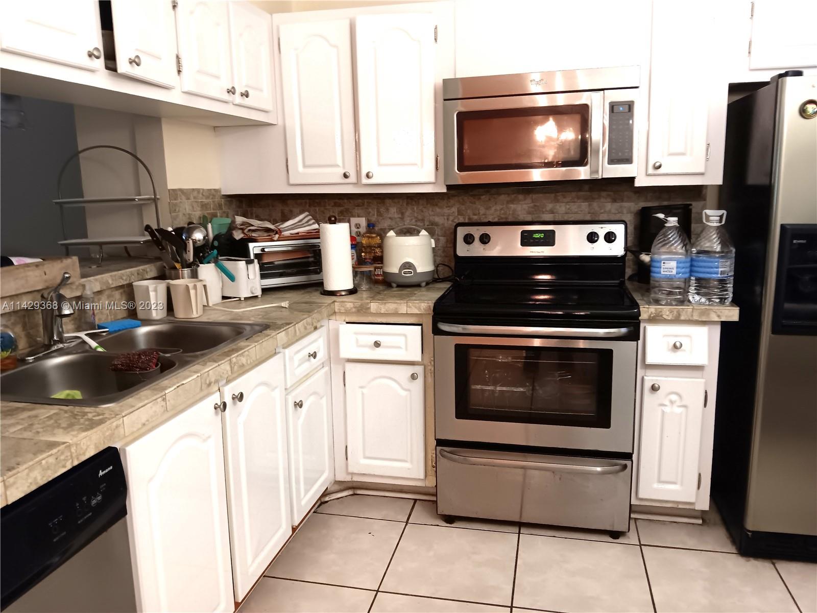 5790 Stirling Road, Unit 311 Hollywood, FL 33021 - Photo 5 of 36 a kitchen with a stove and a microwave