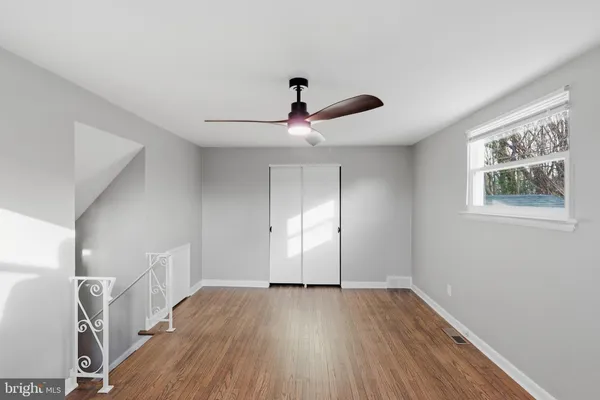 a view of empty room with wooden floor
