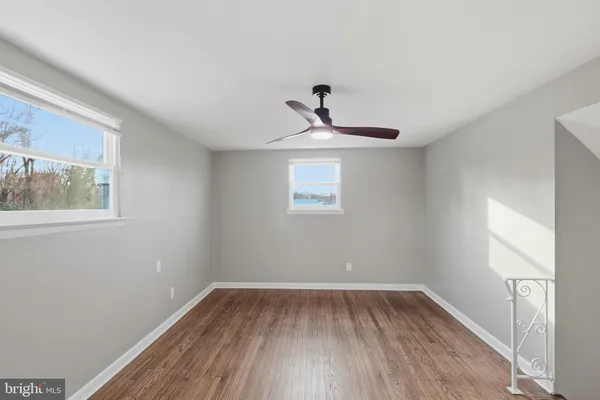 a view of a room with wooden floor and windows