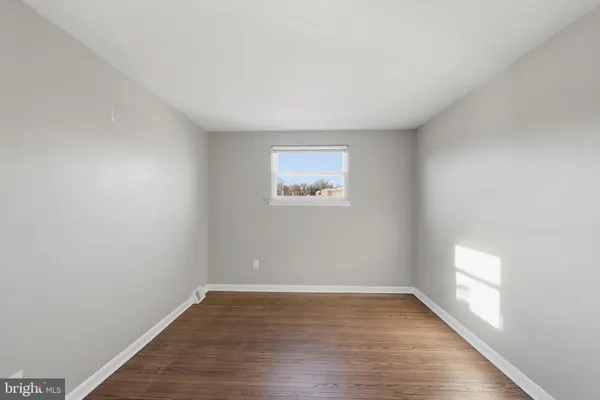 a view of a room that has wooden floor and window