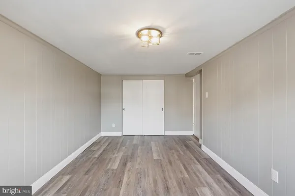 a view of a room with wooden floor and a ceiling fan