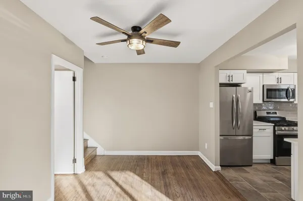 a view of a kitchen with a sink refrigerator and wooden floor