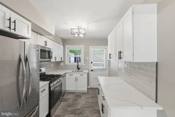 a large kitchen with stainless steel appliances a refrigerator sink and cabinets