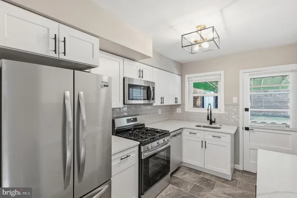 a kitchen with cabinets stainless steel appliances and a window