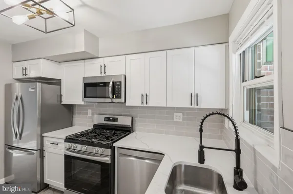 a kitchen with stainless steel appliances granite countertop a stove a refrigerator and a microwave