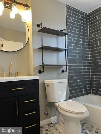 a bathroom with a toilet a sink and mirror