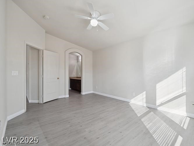 4675 Color Up Court, Unit 101 Las Vegas, NV 89122 - Photo 7 of 19 Unfurnished room featuring light wood finished floors, arched walkways, and ceiling fan